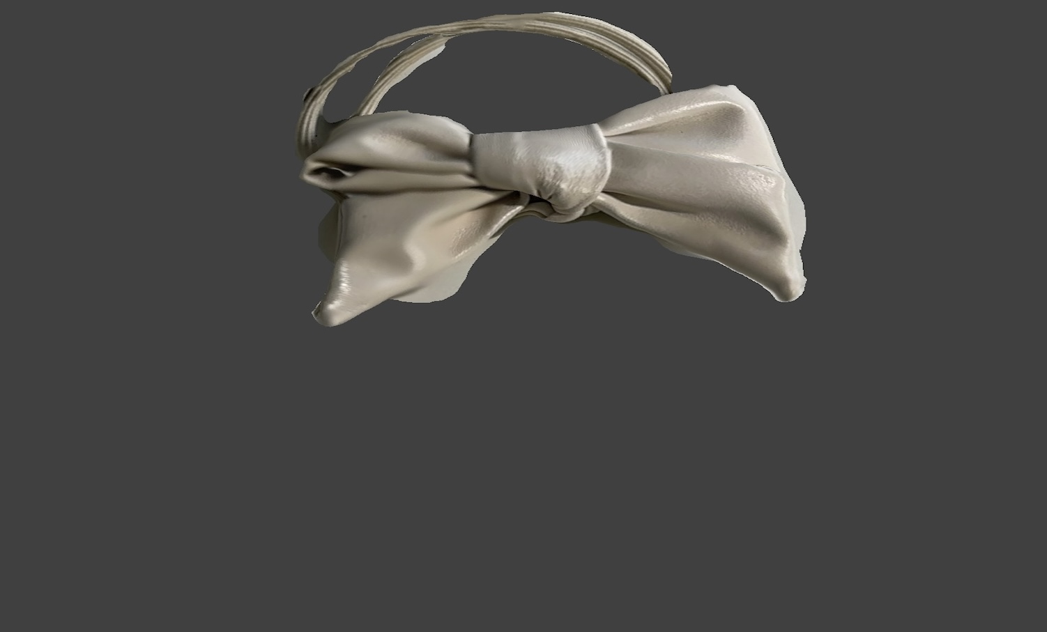 Top view of the hair tie. The final scan quality was not very good. The bow shape was captured, because the string is so narrow, the scanner picked up surrounding textures and merged them incorrectly.